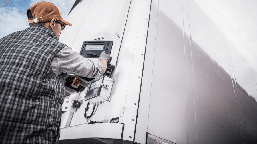 Person operating temperature control panel on refrigerated truck trailer