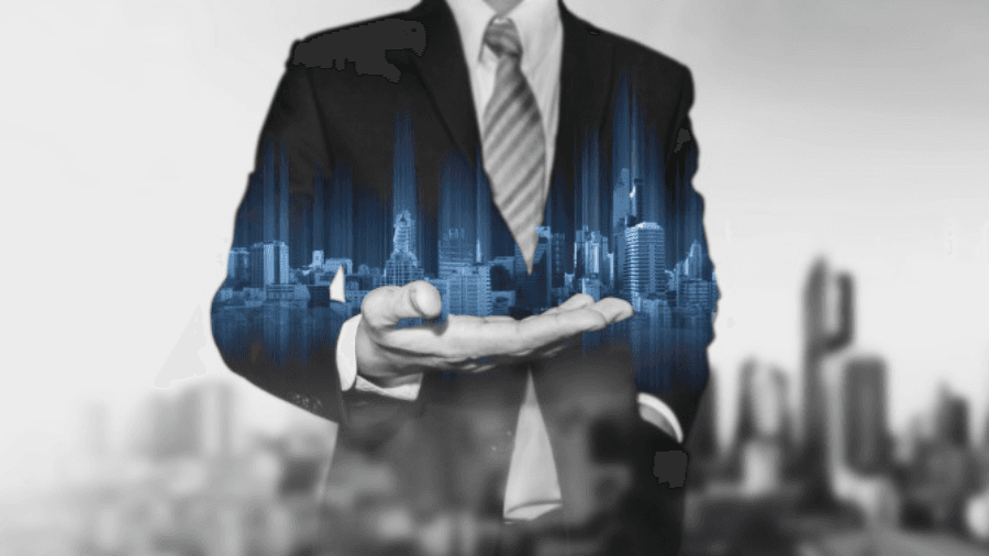 Business person with a hologram of a city in the palm of their hand
