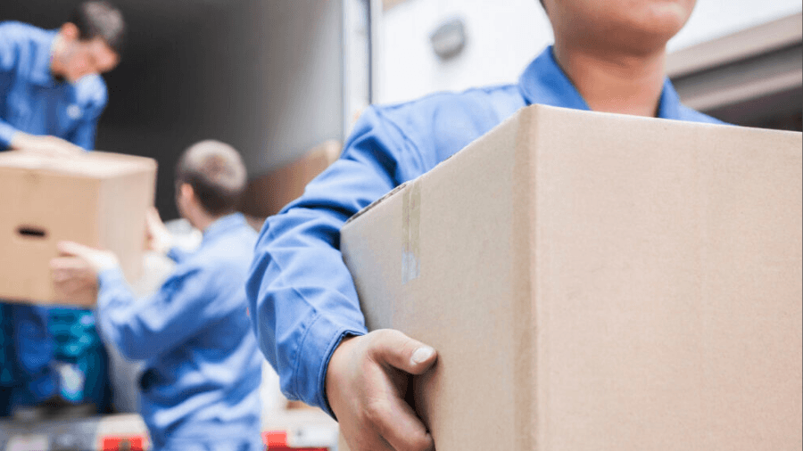 Three people moving boxes out of a removalist van