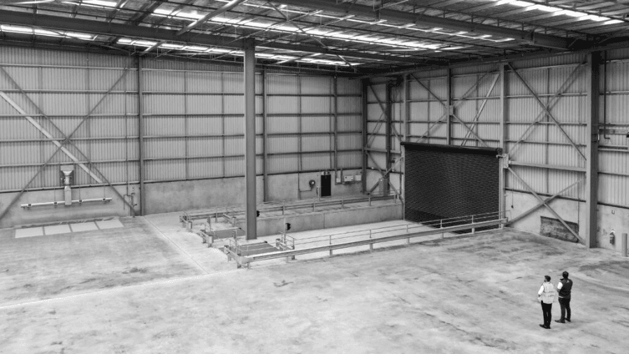 Two people standing in a new empty industrial property (warehouse).