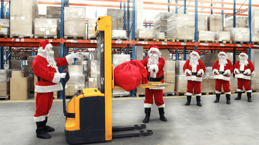 Santa Clauses lined up in a warehouse