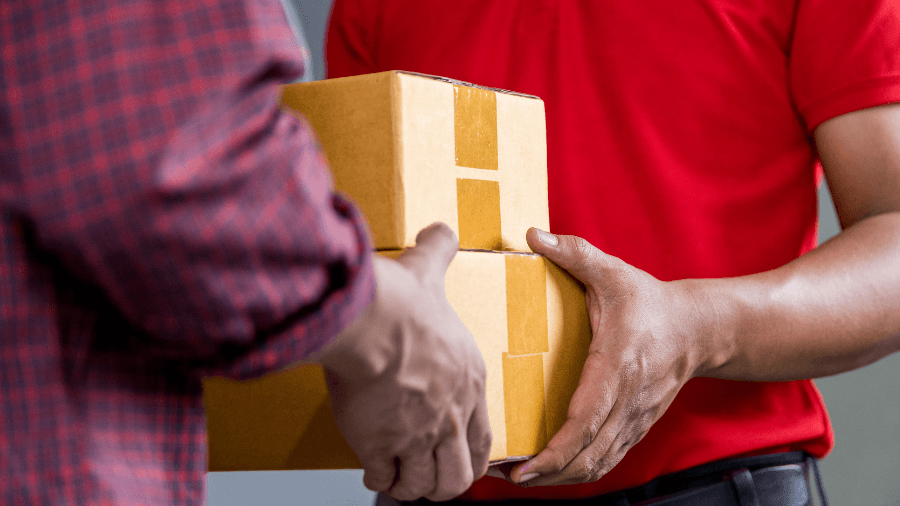 Delivery person handing two small boxes to person
